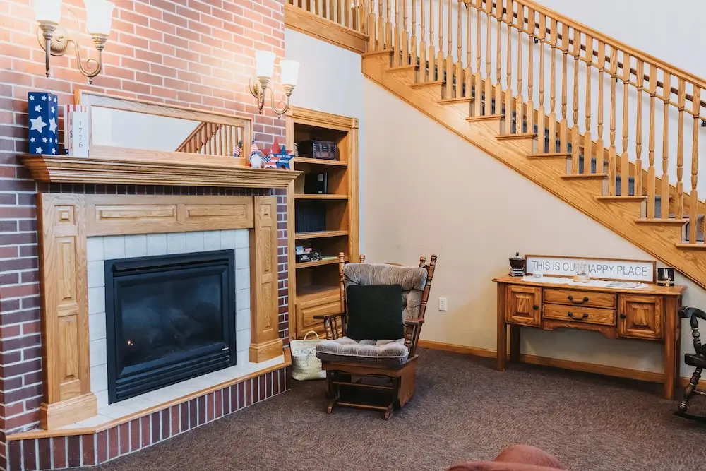 Brick fireplace and rocking chair in the French Meadow Place sitting area