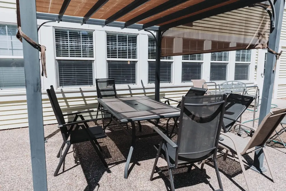 Covered patio with a dining set under a pergola at French Meadow Place